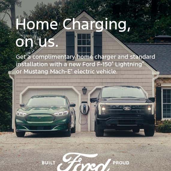 Two Ford electric vehicles parked in a driveway with a home charger offer.
